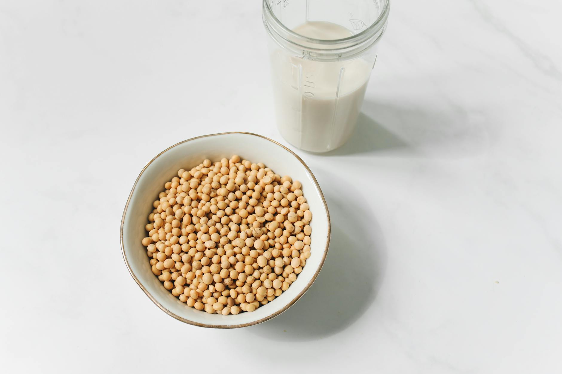 photo of soybeans near drinking glass with soy milk