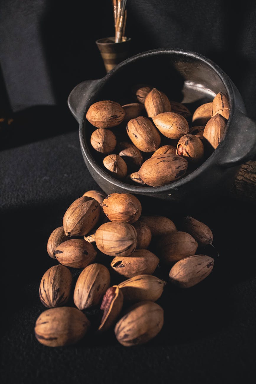 a bowl of pecan nuts in shells